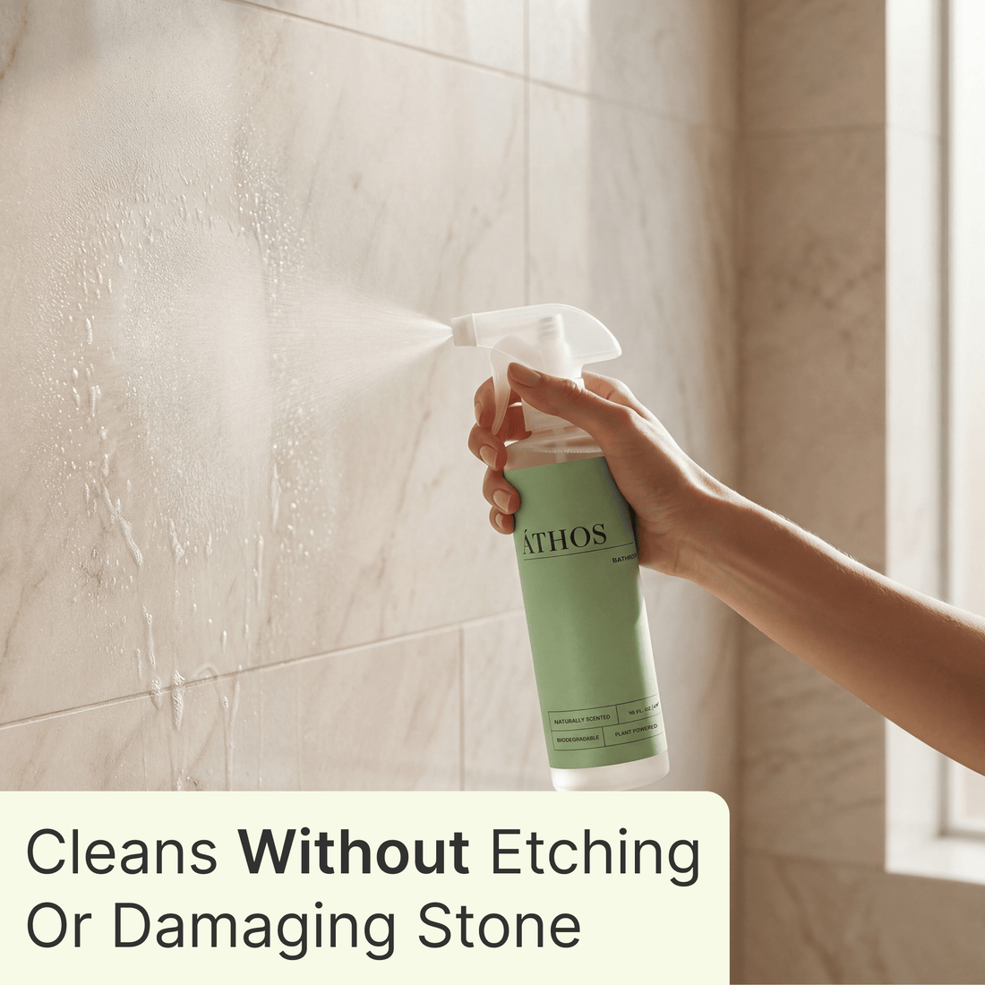 A hand working on a shower wall to show targeted cleanup on one visible problem area.